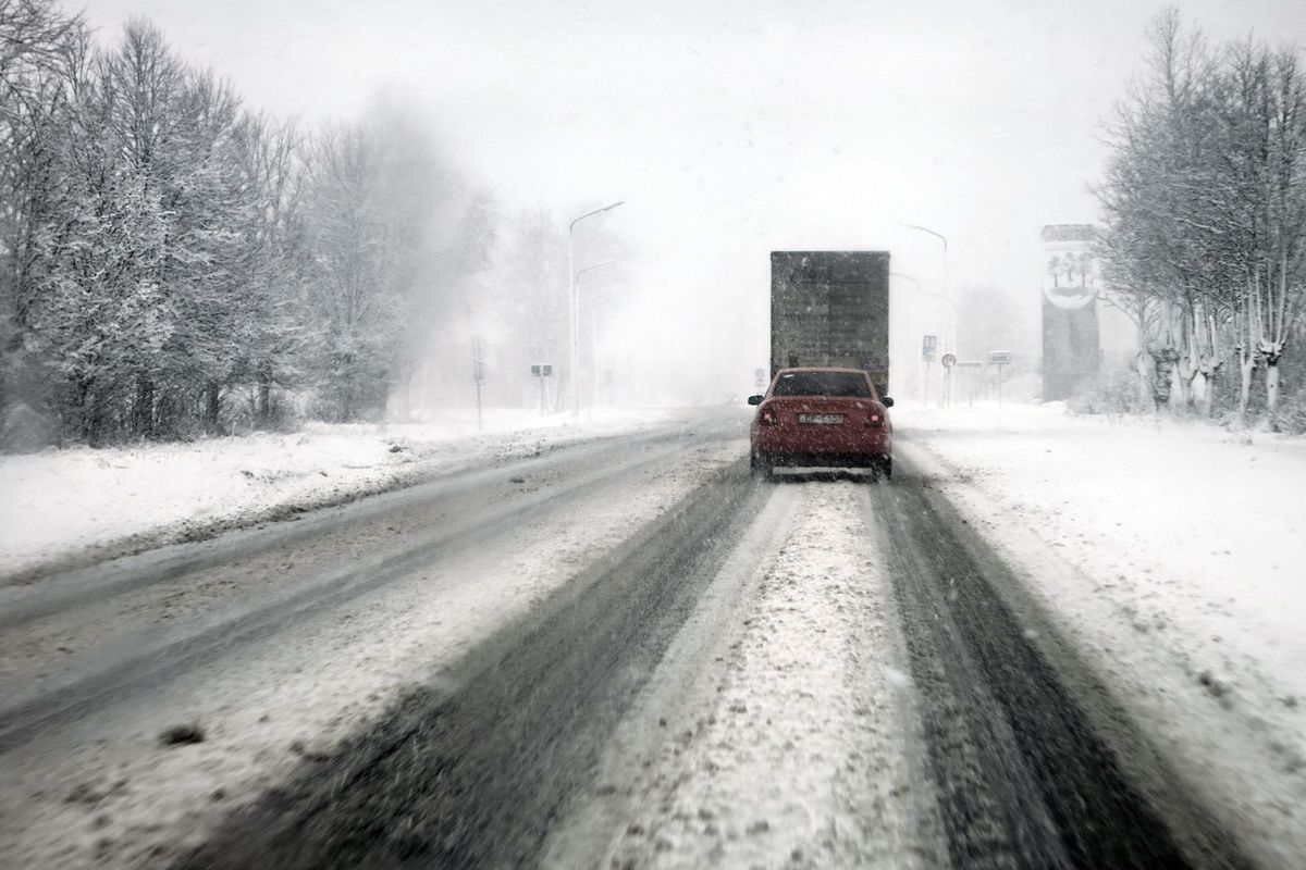 Cars driving on a snowy highway during a blizzard